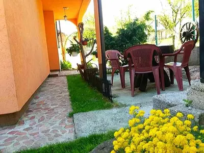 a patio with a table and chairs and yellow flowers at Apartman Fantasy Zavidovici in Zavidovići