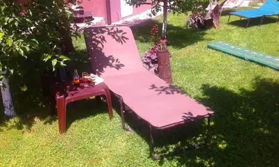 a pink chair and a bench in the grass at Apartman Fantasy Zavidovici in Zavidovići