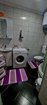 a bathroom with a washing machine and a sink at Apartman Fantasy Zavidovici in Zavidovići