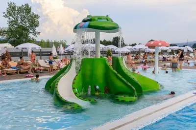 a water slide in a swimming pool with people playing at Hotel Terme Ozren in Bosansko Petrovo Selo