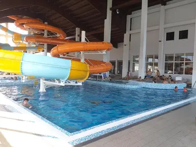 a swimming pool with a water slide in a building at Hotel Terme Ozren in Bosansko Petrovo Selo