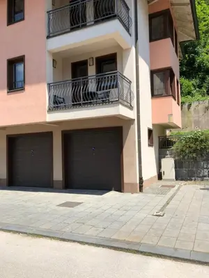 a building with two garage doors and a balcony at Street View Apartman in Fojnica