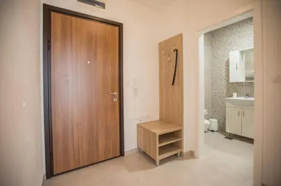 a bathroom with a wooden door and a sink at Jelena Apartment II in Doboj