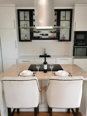 a kitchen with a table with two glasses of wine at Luxury Apartment with a stunning view, FREE parking in Tuzla