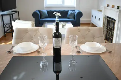 a bottle of wine sitting on a table with glasses at Luxury Apartment with a stunning view, FREE parking in Tuzla