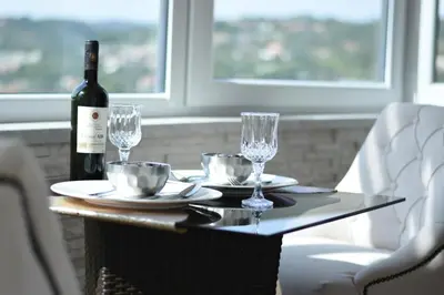 a table with a bottle of wine and glasses at Luxury Apartment with a stunning view, FREE parking in Tuzla
