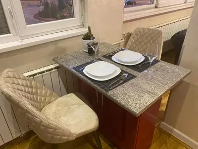 a table with two chairs and plates and wine glasses at Apartman 