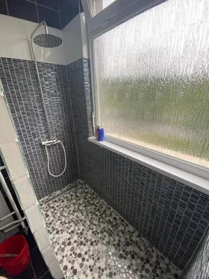 a shower with a glass window in a bathroom at Apartman 