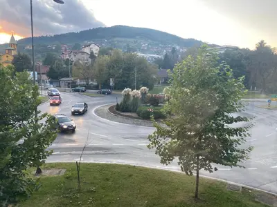 a street with cars parked in a parking lot at Apartman 