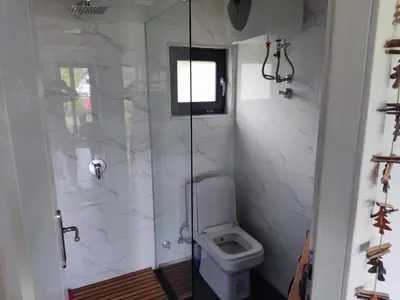 a bathroom with a toilet and a glass shower at Residence Wood Pool & SPA in Visoko