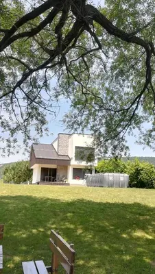 a house in a field with a bench in front of it at Villa Una Sunset in Bihać