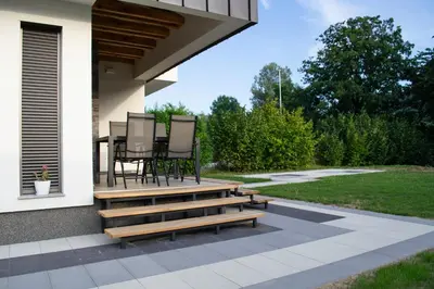 a patio with a table and chairs on a porch at Villa Una Sunset in Bihać