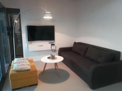 a living room with a couch and a table and a tv at Villa Una Sunset in Bihać