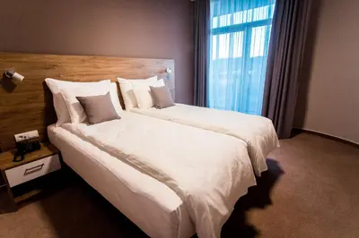 a bedroom with a large white bed with a window at Hotel IN in Banja Luka