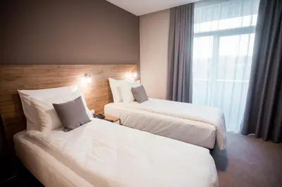 a hotel room with two beds and a window at Hotel IN in Banja Luka