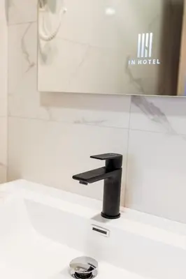 a bathroom sink with a black faucet at Hotel IN in Banja Luka