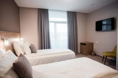 a hotel room with two beds and a television at Hotel IN in Banja Luka