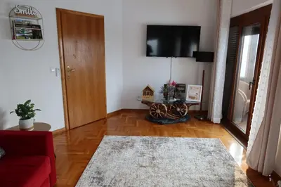 a living room with a red couch and a tv at The View Apartment in Visoko