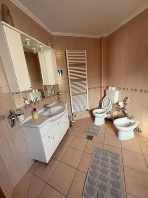 a bathroom with two sinks and a toilet and a mirror at The View Apartment in Visoko