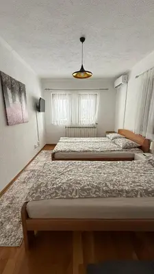 a large bedroom with two beds and a chandelier at The View Apartment in Visoko