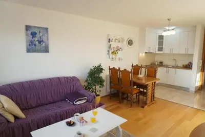 a living room with a purple couch and a table at Apartman Perunika in Kupres