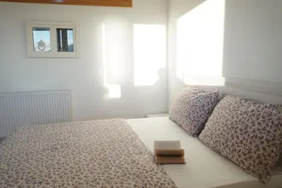 a bed with two pillows and a book on it at Apartman Perunika in Kupres
