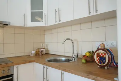 a kitchen with white cabinets and a sink at Apartman Perunika in Kupres