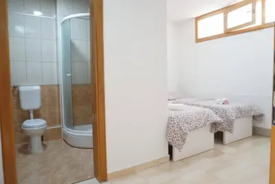 a bathroom with a shower and a toilet and a sink at Apartman Perunika in Kupres