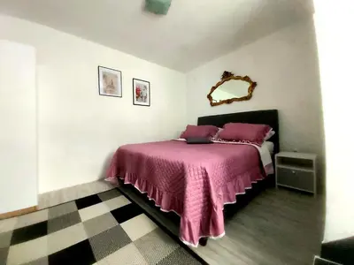 a bedroom with a bed with a pink blanket at APARTMAN ANDREA 4 in Banja Luka
