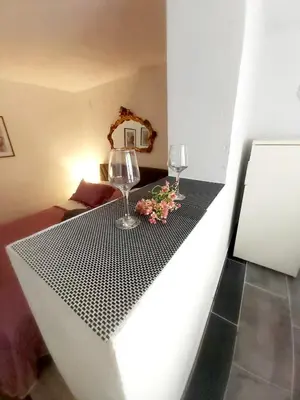 a table with two wine glasses and flowers on it at APARTMAN ANDREA 4 in Banja Luka