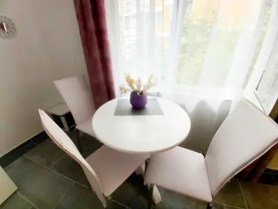 a white table and chairs in a room with a window at APARTMAN ANDREA 4 in Banja Luka