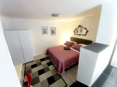 a small bedroom with a bed with a pink blanket at APARTMAN ANDREA 4 in Banja Luka