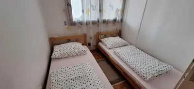 a small room with two beds and a mirror at Apartman UNA Travnik in Travnik