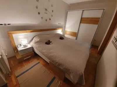 a bed with a cat laying on top of it at Apartman Lari in Vlasic