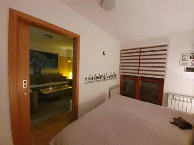 a bedroom with a bed and a living room at Apartman Lari in Vlasic