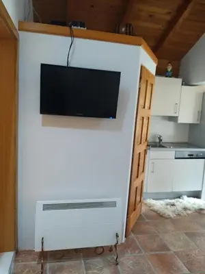a living room with a tv on a wall at COUNTRY HOUSE in Bihać