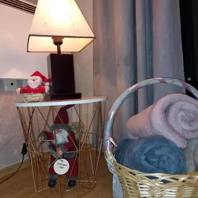 a table with a lamp next to a chair and a table with a basket at Apartman Zlaja Vlašić in Vlasic