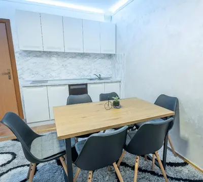 a dining room with a wooden table and chairs at Alpin Apartments Vlašić in Vlasic