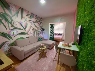 a living room with a couch and a flower wall at Alpin Apartments Vlašić in Vlasic
