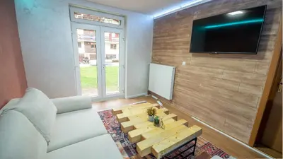 a living room with a white couch and a table at Alpin Apartments Vlašić in Vlasic