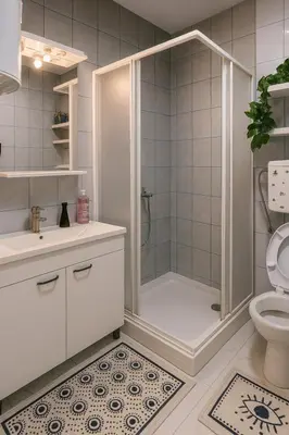a white bathroom with a shower and a toilet at Alpin Apartments Vlašić in Vlasic