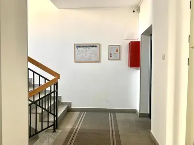 a hallway with stairs and a sign on a wall at All White in Banja Luka