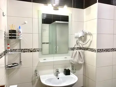 a white bathroom with a sink and a mirror at All White in Banja Luka