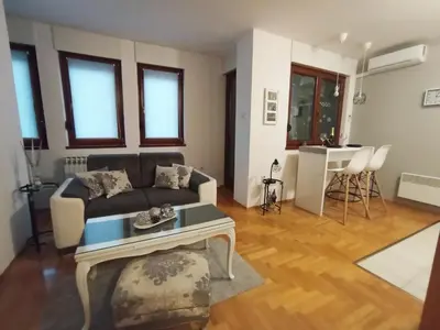 a living room with a couch and a table at All White in Banja Luka
