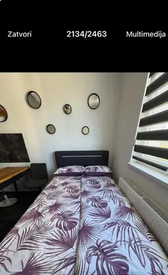a bedroom with a bed with a purple blanket at Apartman CITY CENTER 2 in Prijedor