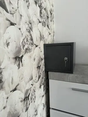 a wall with a floral wallpaper with a drawer at Apartman CITY CENTER 2 in Prijedor