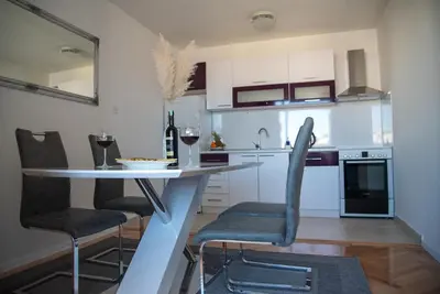 a kitchen with a table and chairs in a room at Apartman Ante in Livno