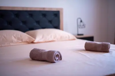 a bed with two rolled up towels on it at Apartman Ante in Livno