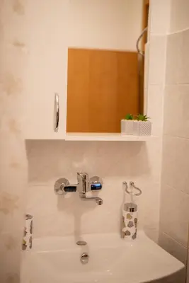 a sink in a bathroom with a mirror above it at Apartman Ante in Livno