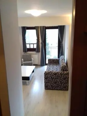a living room with a couch and a table and windows at City View Apartment in Fojnica
